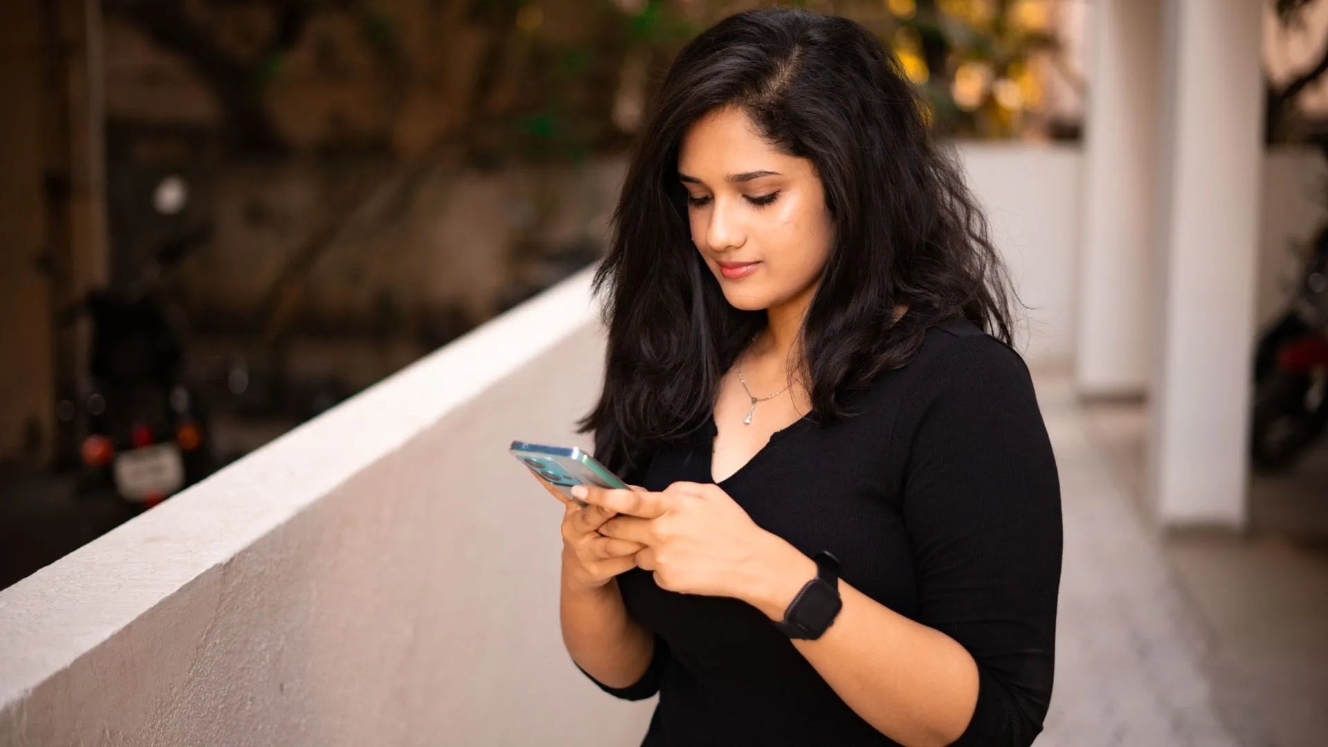 Young Indian woman scrolling social media on her smartphone